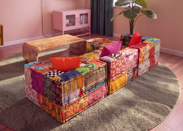 Sz&iacute;nes patchwork modul&aacute;ris kanap&eacute; fa doh&aacute;nyz&oacute;asztal k&ouml;r&eacute; rendezve, kerek szőnyegen, egy modern nappaliban.