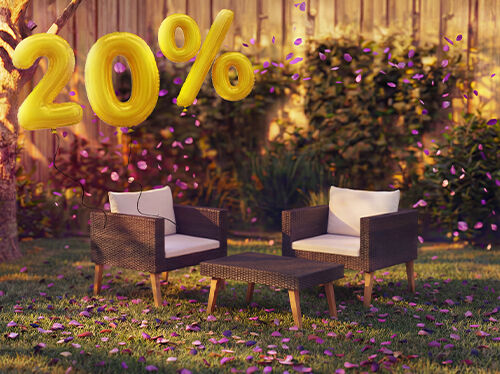K&uuml;lt&eacute;ri rattan lounge fotelek p&aacute;rn&aacute;kkal &eacute;s egy kis asztallal kerti k&ouml;rnyezetben, r&oacute;zsasz&iacute;n konfettivel &eacute;s arany &bdquo;20% kedvezm&eacute;ny&rdquo; felirat&uacute; lufikkal d&iacute;sz&iacute;tve, kiemelve a kerti lounge b&uacute;torok szezon&aacute;lis aj&aacute;nlatait.